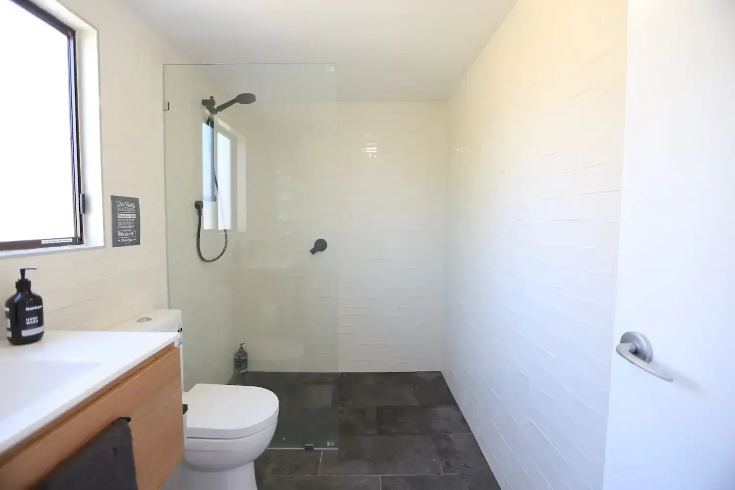 Ensuite renovation with glass shower and white tiling